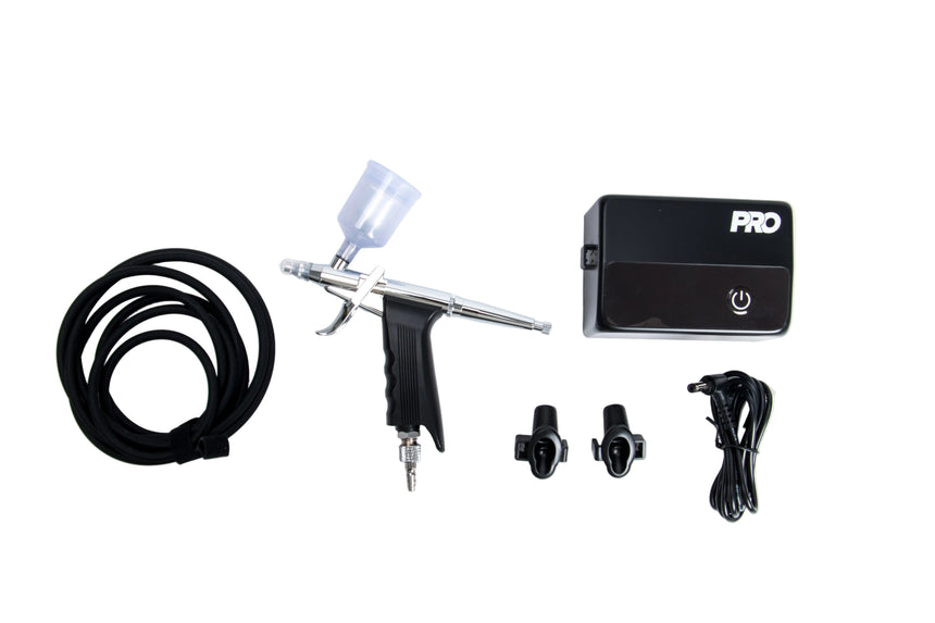 Airbrush kit with gun, power supply, and accessories on a white background