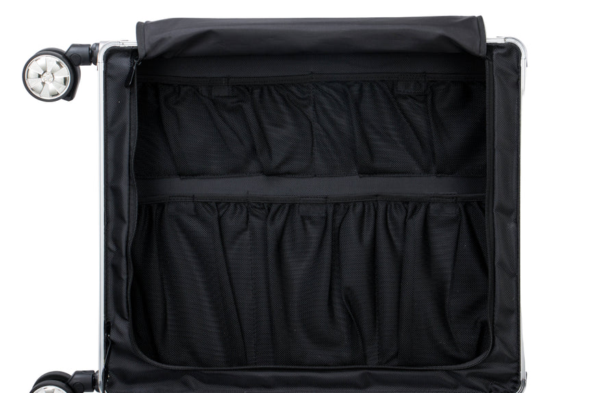 Black suitcase with open compartment on a light gray background