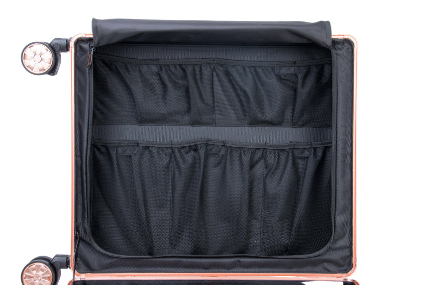 Open suitcase with black interior compartments on a light gray background
