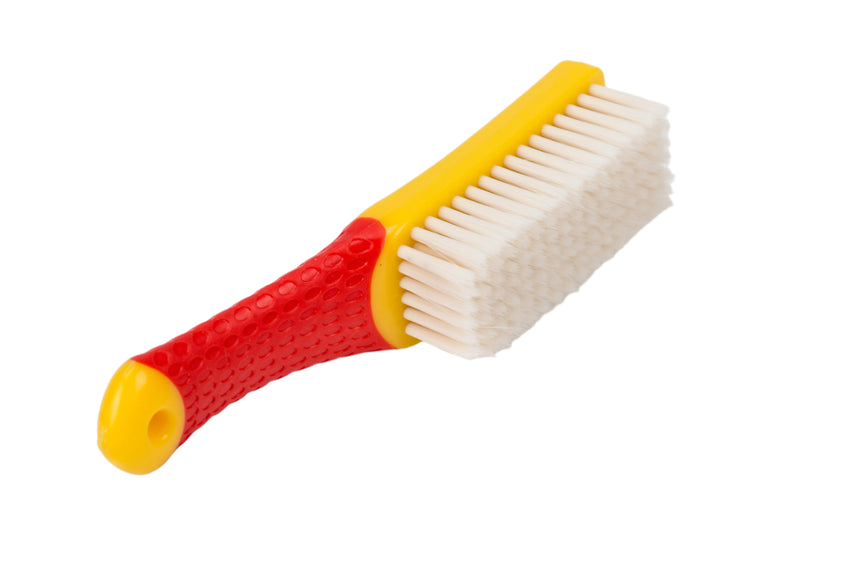 Red and yellow brush with white bristles on a light gray background