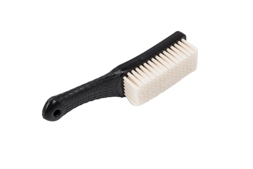 Black brush with white bristles on a light gray background