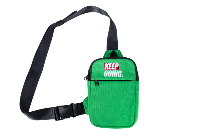 Green crossbody bag with 'KEEP GOING.' text on a white background