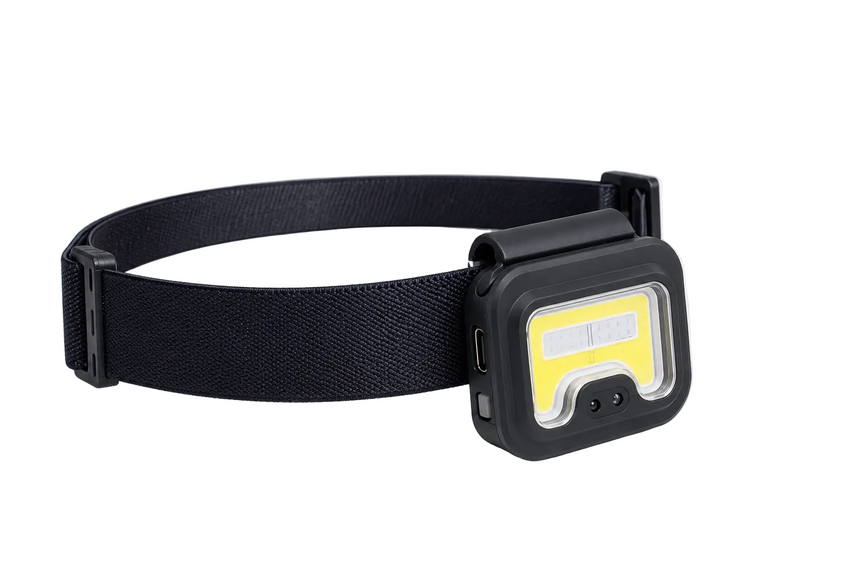 Black headlamp with a yellow label on a white background