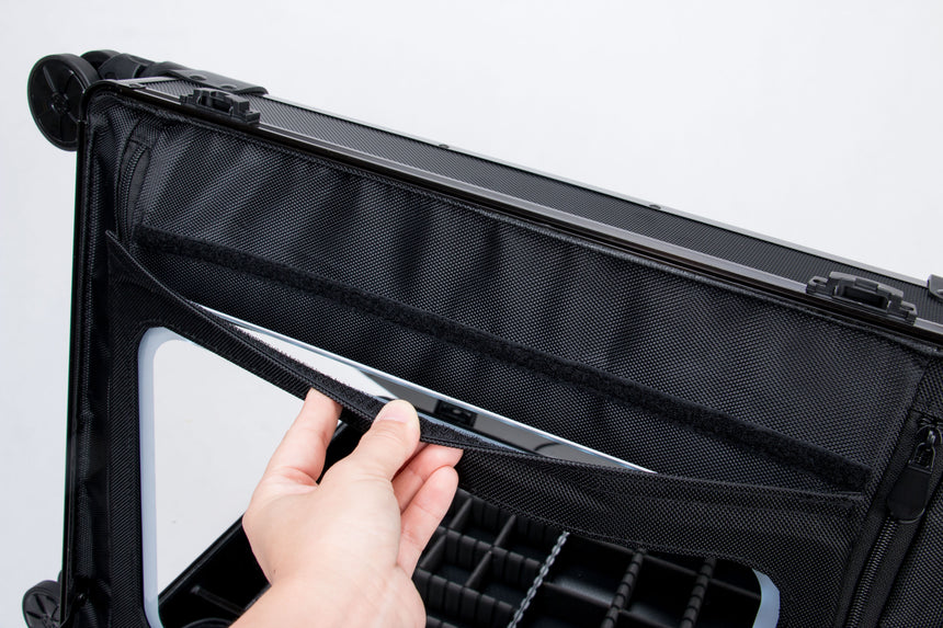 Hand opening a black suitcase with a white interior