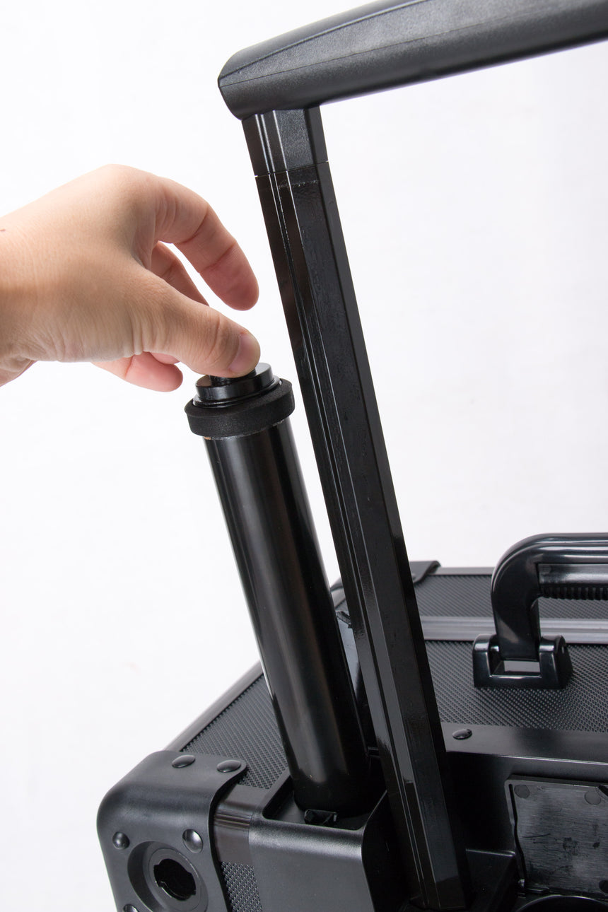 Hand adjusting a black shock absorber on a vehicle