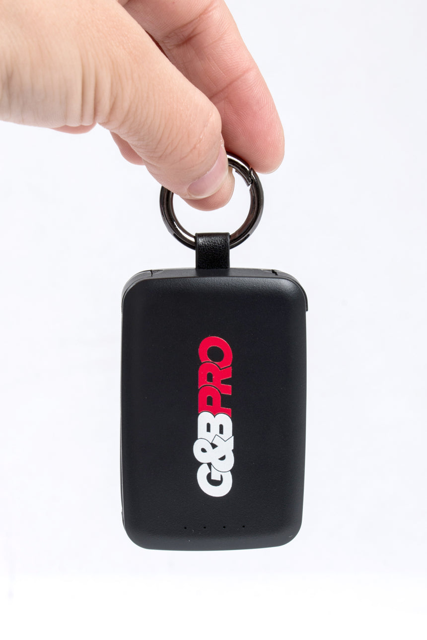 Black G&G Pro device held by a hand on a white background