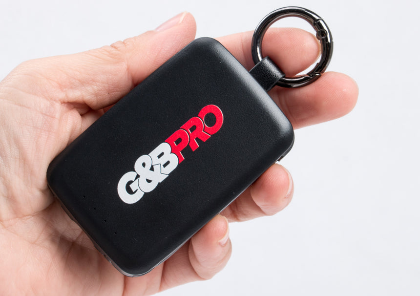 Black device with 'G&B Pro' logo held in a hand against a white background