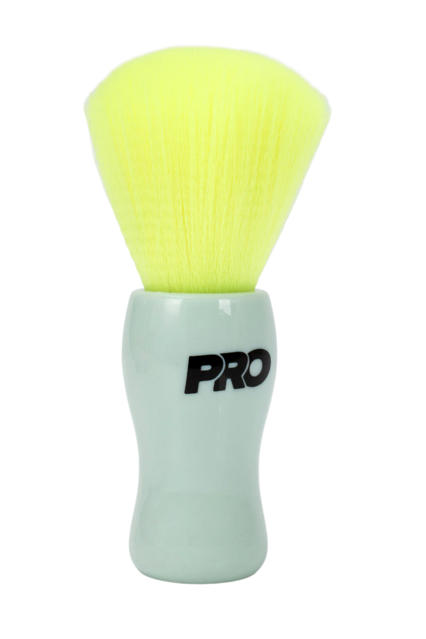 Cosmetic brush with green bristle head and white handle featuring 'PRO' branding on a light gray background